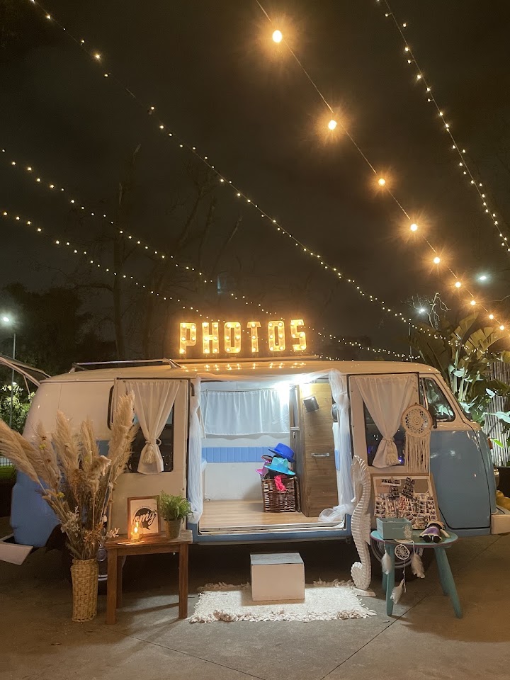 Photo Bus Vintage Kombi en una boda al aire libre con luces cálidas